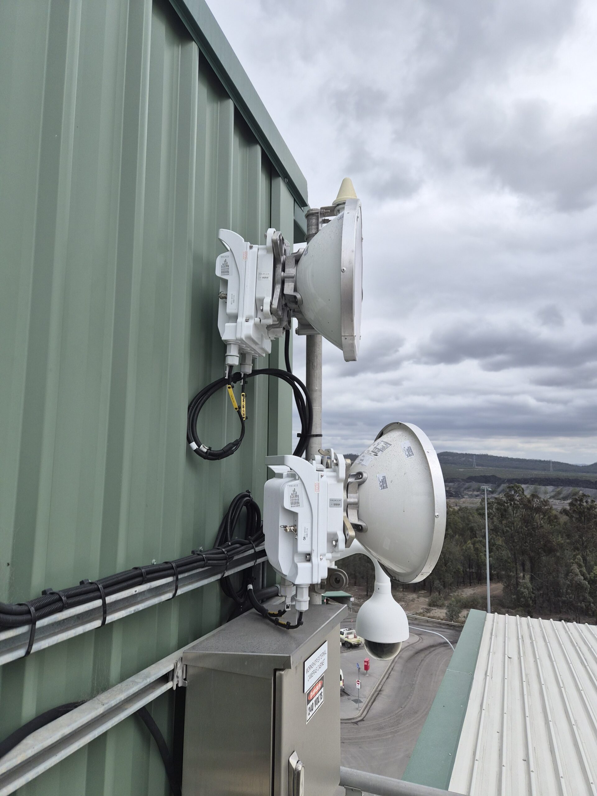Microwave backhaul radios mounted on a workshop building at an open cut coal mine site